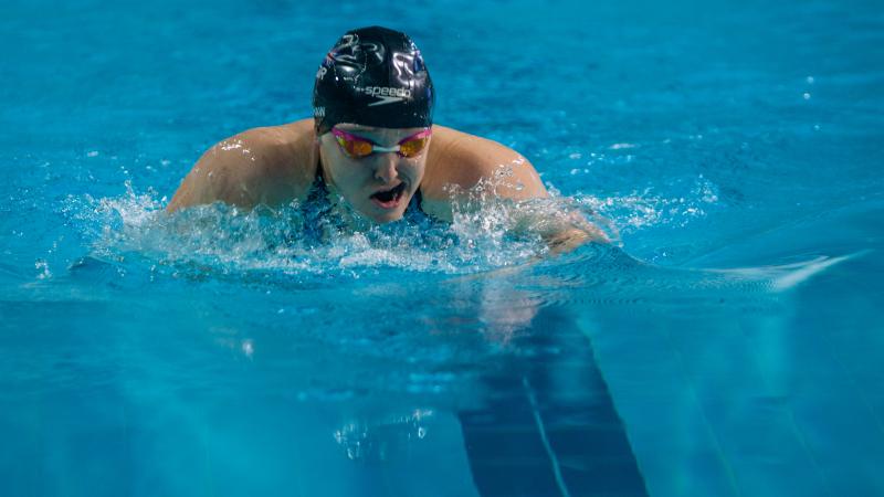 Female swimmer takes a breath between strokes