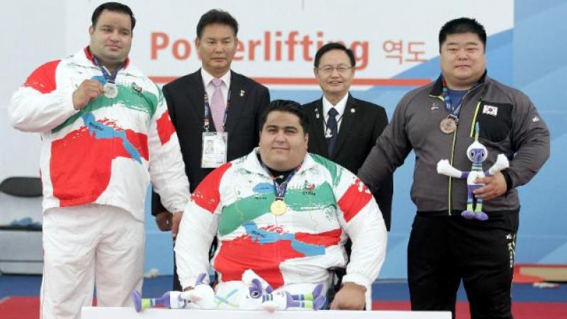 Three athletes on a podium received their medals. 