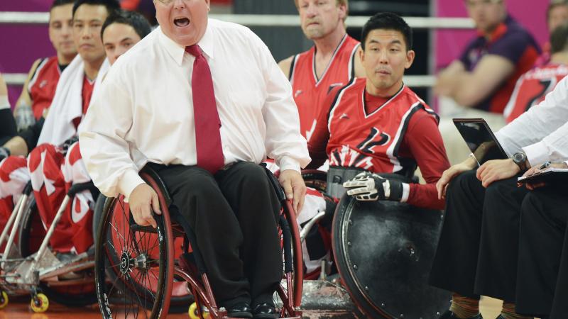 Wheelchair rugby coach in wheelchair yells instructions 