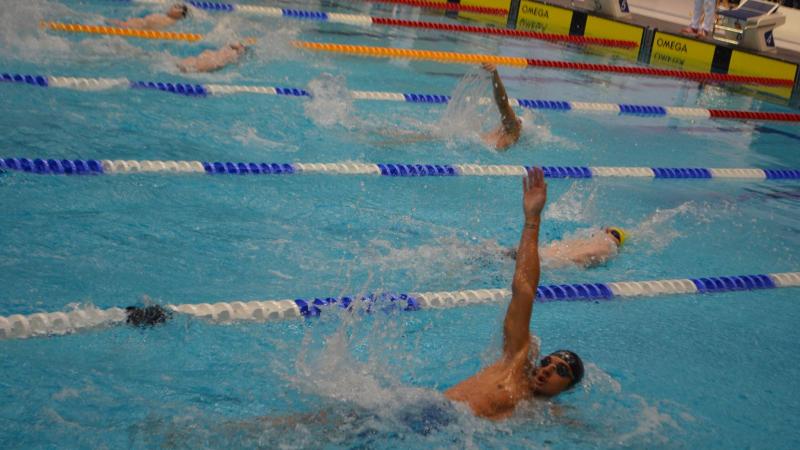 Swimmers compete in a backstroke event. 