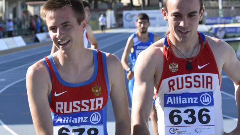 Upper bodies of two men in Russian jerseays on a track