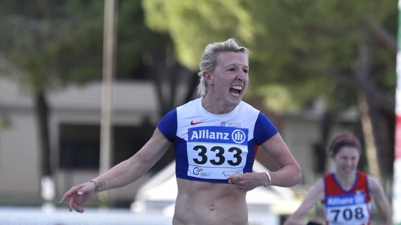 Woman in running shirt crossing the finish 