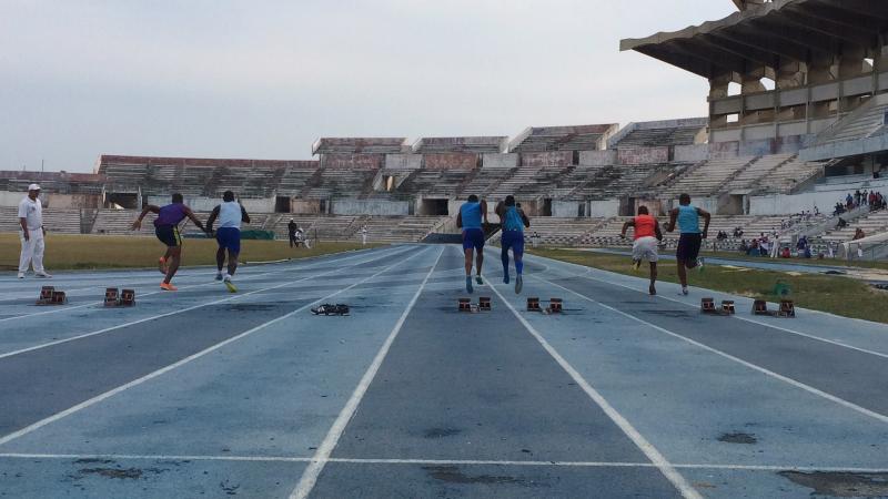Track in an old stadium showing athletes and their guides starting