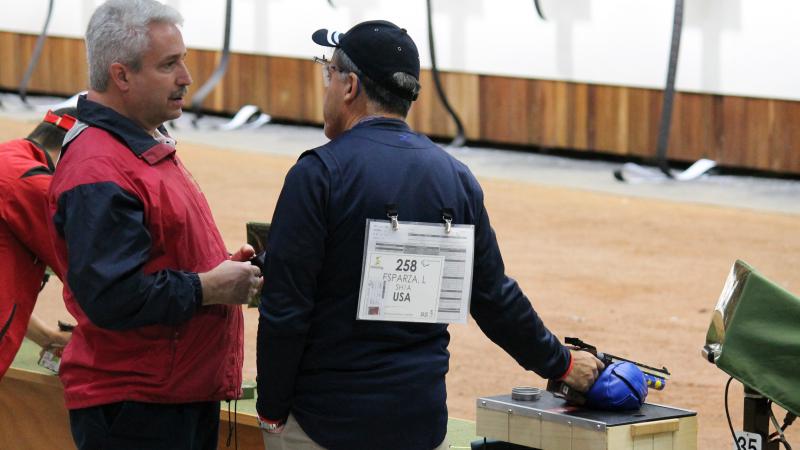 Two men in a shooting range, talking