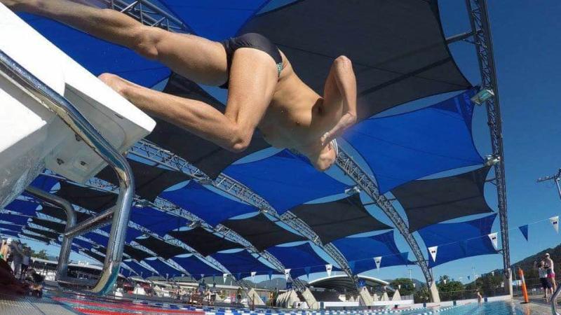 Swimmer jumping from the block into the water