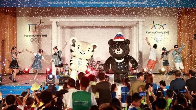 The PyeongChang 2018 full-sized mascots appear on stage in front of a crowd.