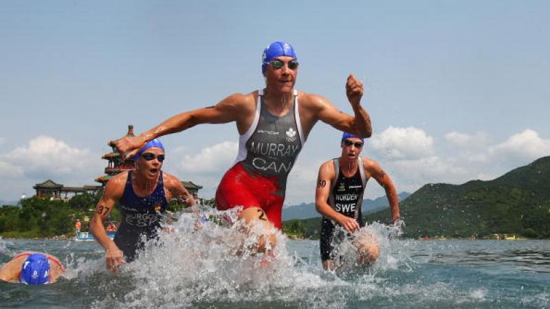 Women in swim suite leaving the water.