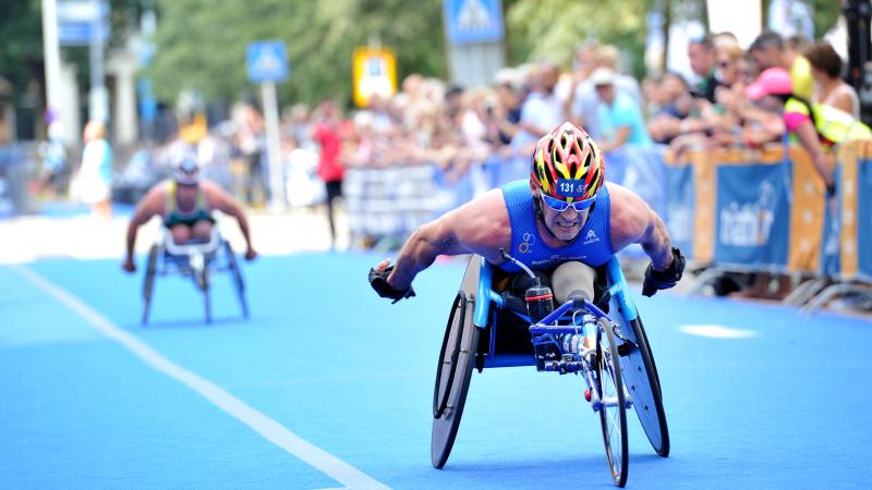 Man in racing wheelchair outside on a street