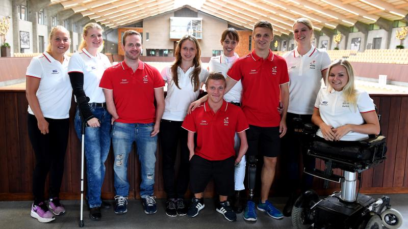Fifteen Danish Para athletes pose for a photo wearing the red and white Danish colours.