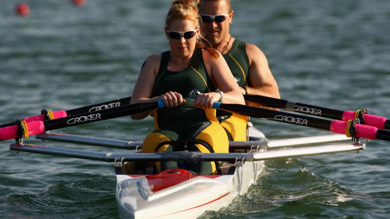 Man male and female rower on boat in the water.