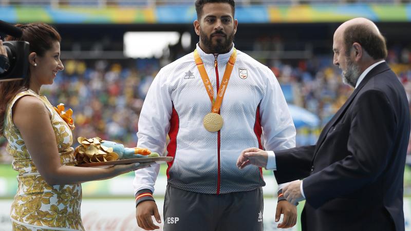 Man on podium receives medal