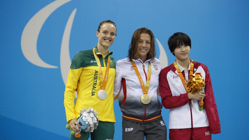 Three women with medals on the podium