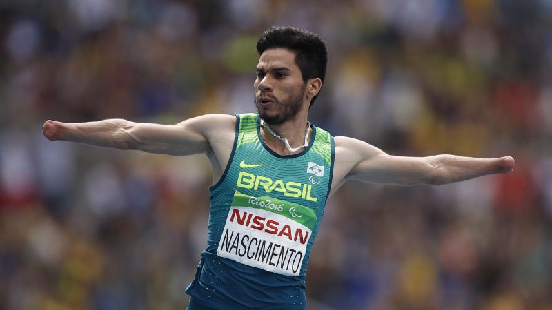 a male Para sprinter celebrates crossing the line