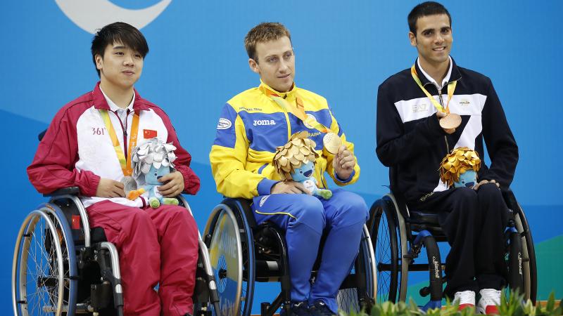 Three medallists in wheelchairs on the podium