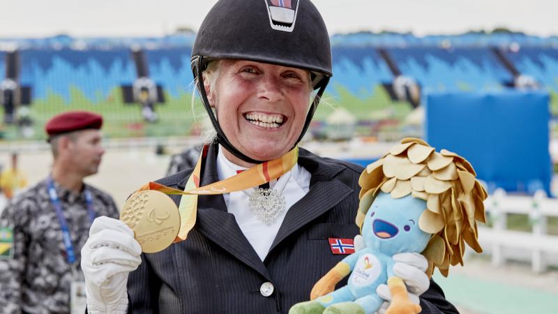 A dressage rider celebrating her medal.