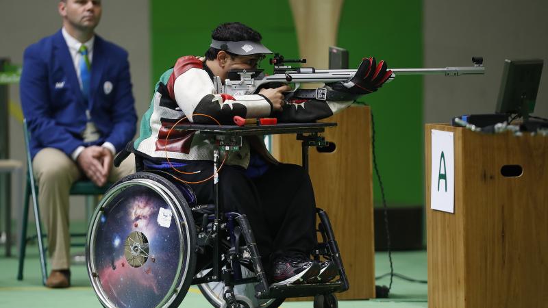 Man in wheelchair in a shooting range, targeting