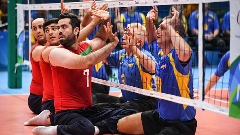 Sadegh Bigdeli of Iran, Petro Ostrynskyi and Sergii Shevchenko of Ukraine compete during Mens Sitting Volleyball match between Iran and Ukraine at the Rio 2016 Paralympic Games.