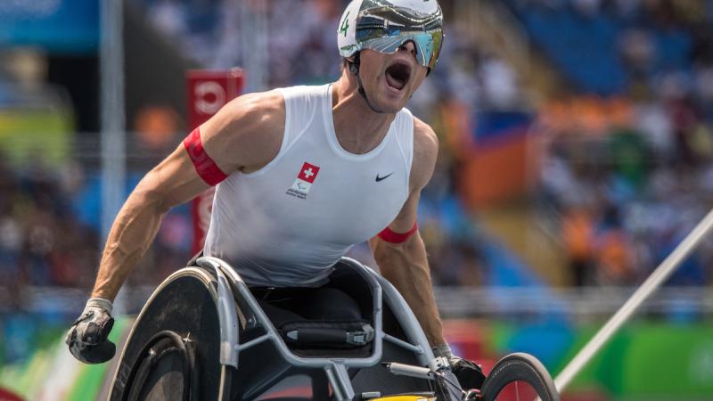 A wheelchair racer celebrates winning gold