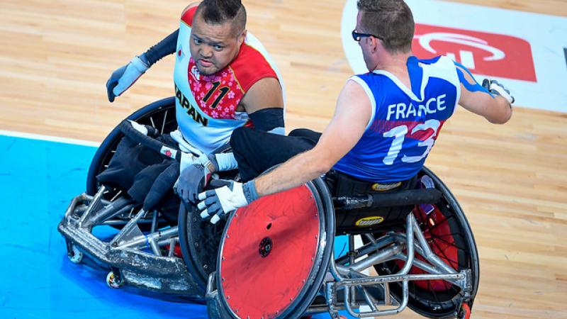 Two wheelchair rugby players crashing into each other