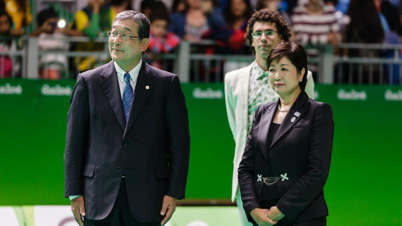 two officials stand together at a medal ceremony