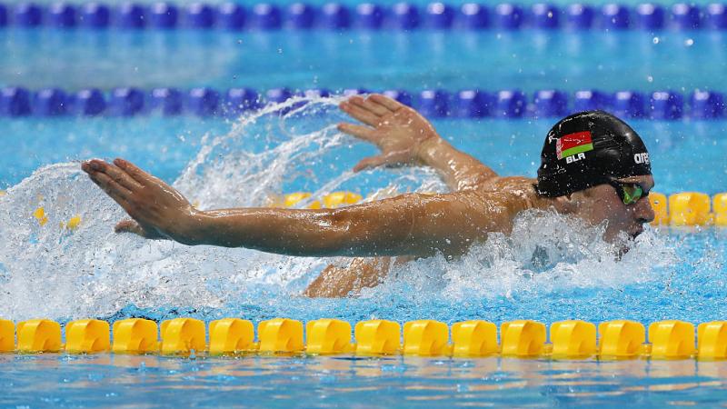 Male swimmer in water competing in butterfly stroke