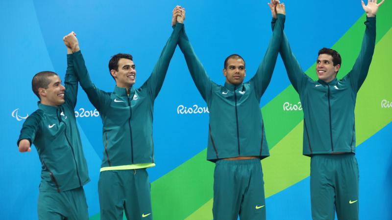 Four Brazilian swimmers on a podium celebrating