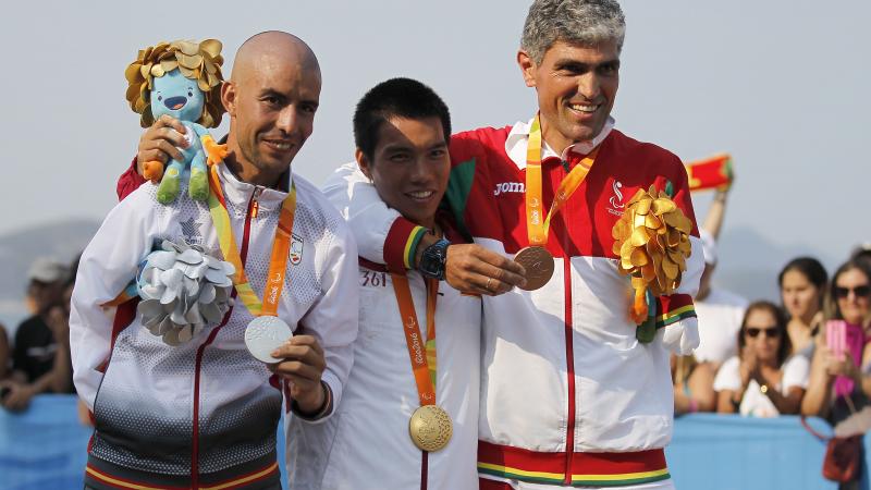 Three men on the podium, smiling