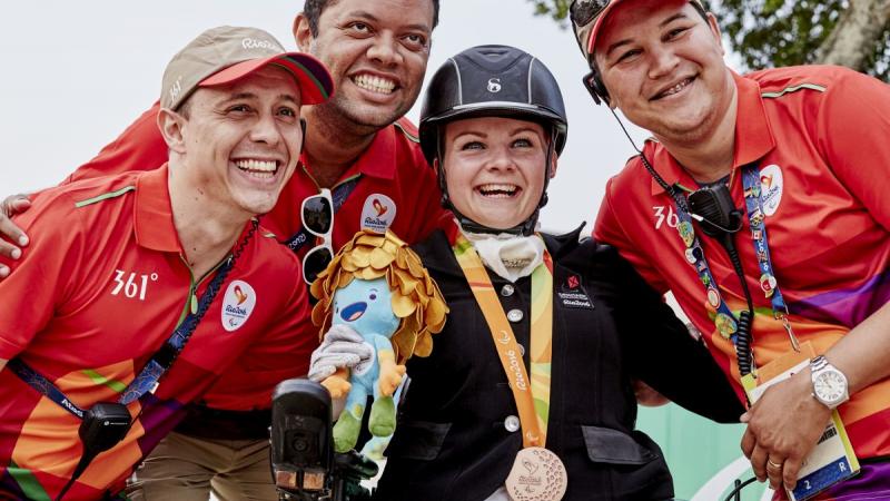 Stinna Tange Kaastrup celebrating her gold medal with volunteers.