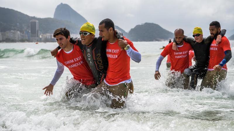Mohamed Lahna MAR (left) and Stephane Bahier FRA are aided out of the water during the Men's PT2 Triathlon competition at Fort Copacabana.