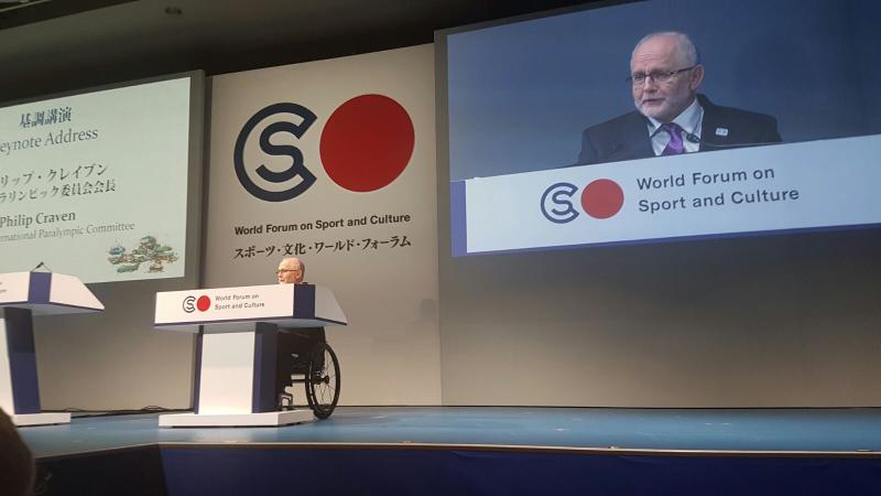 Man in wheelchair on stage giving a speech