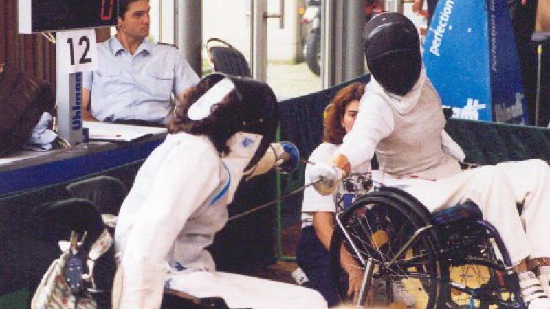 Two people in wheelchairs, fencing