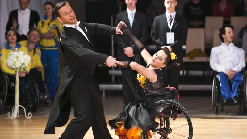 A woman in wheelchair dances with a man standing up