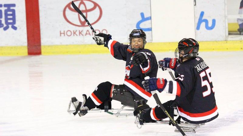 Two ice sledge hockey players on the ice