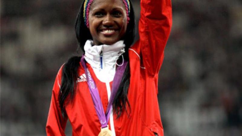 A picture of a woman showing her gold medal