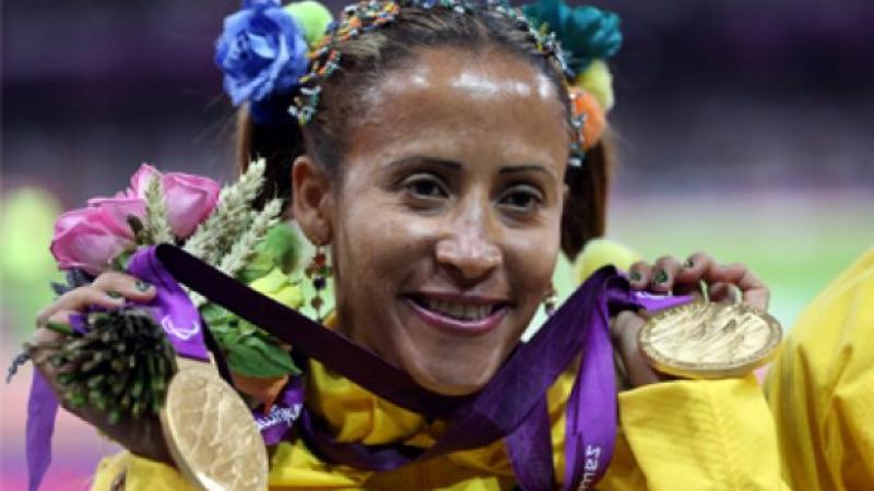 A picture of a woman showing her both gold medals