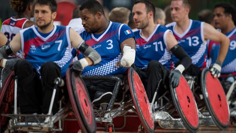 Men in wheelchairs form a line