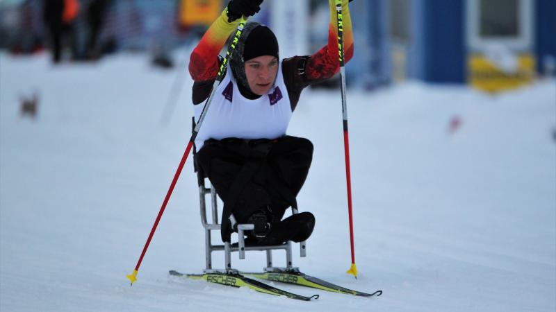 Woman with no legs in sit ski on a slope