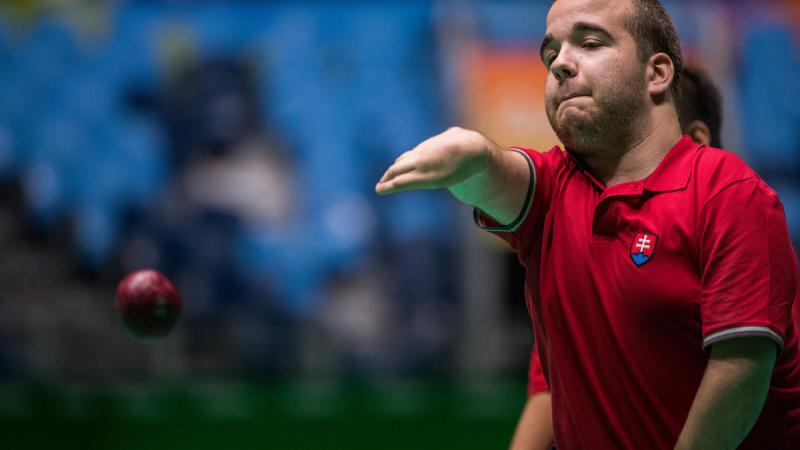 Upper body of man throwing a red ball