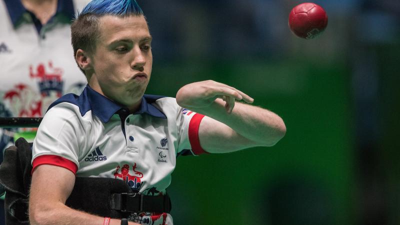 Upper body of man throwing a red ball