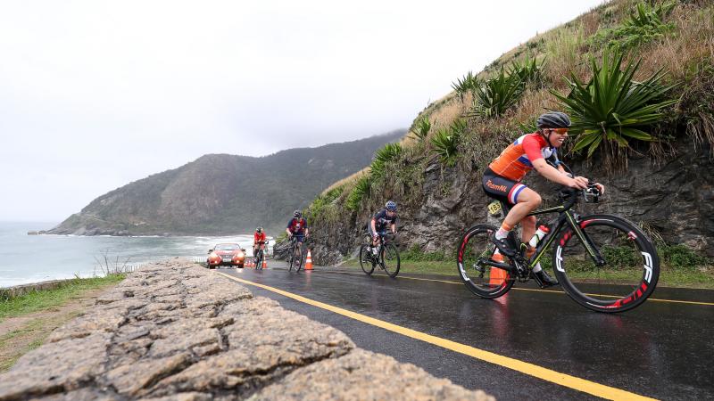 A group of cyclists climbing up a hill in a road race