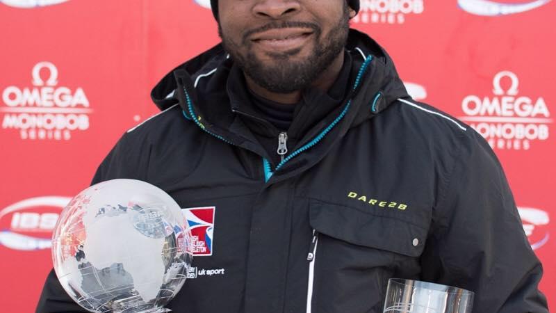 Profile picture of a man who smiles and holds a trophy in his hands