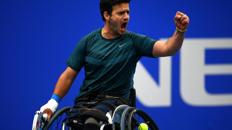 Wheelchair tennis player pumping his fist.