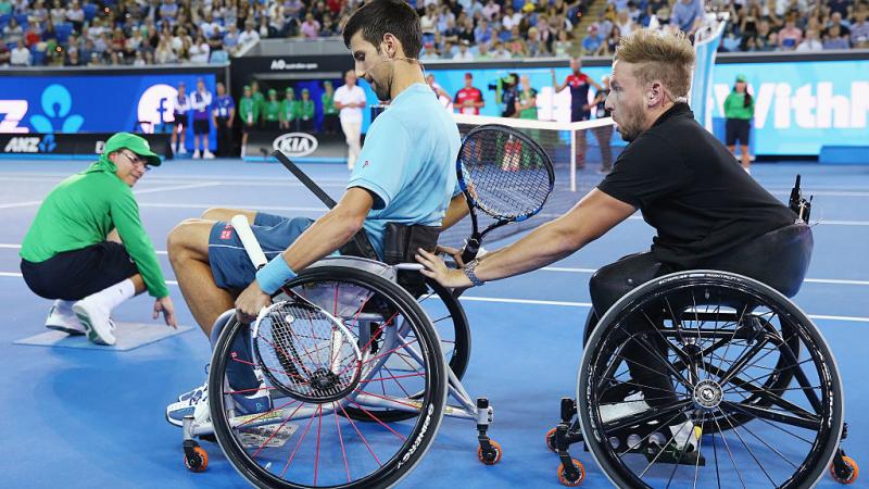 Two men in wheelchairs on a tennis court