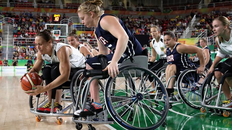 Two women in wheelchairs on the basketball court