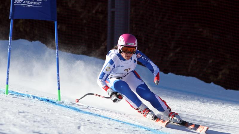 a female Para skier rounds a gate