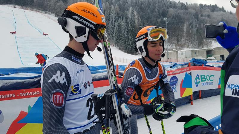 A visually impaired skier and guide in the mixed zone