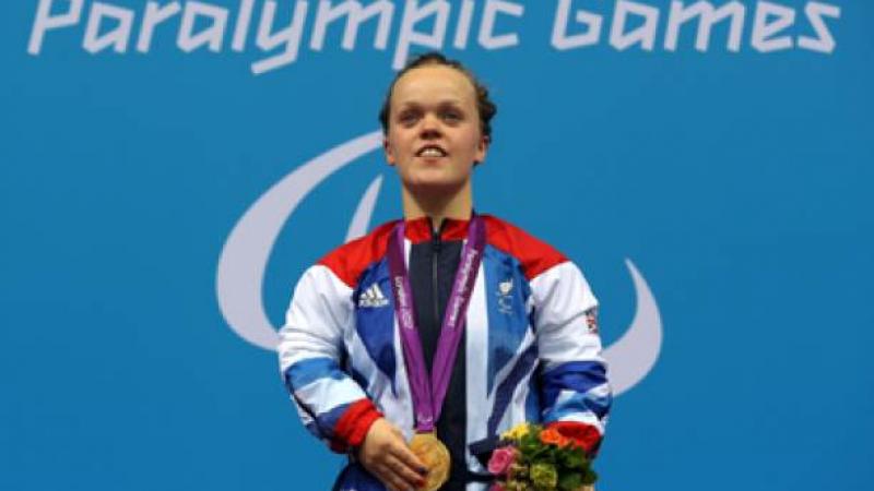 A picture of a woman with a gold medal around her neck