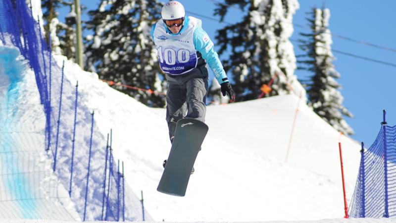 Man on snowboard flies over a jump