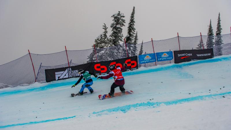 Two men on snowboards race