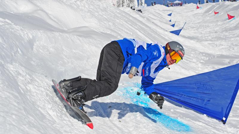 Man on snowboard turns on a banked slope